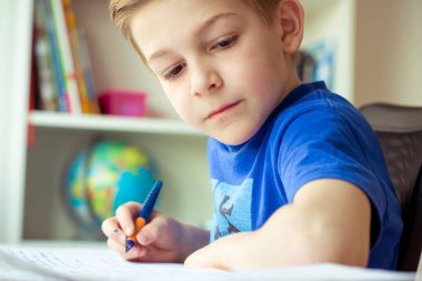 Akıllı çocuk ev ödevi odasında yapar.
