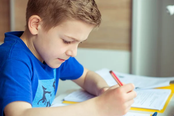 Inteligente chico hace la tarea en su habitación — Foto de Stock