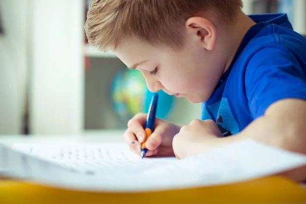 Intelligent boy makes homework in his room — Stock Photo, Image