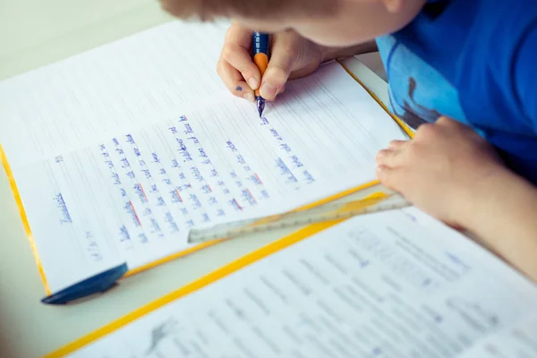 Intelligent boy makes homework in his room — Stock Photo, Image