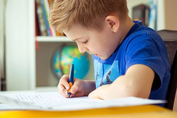 Intelligent boy makes homework in his room — Stock Photo, Image