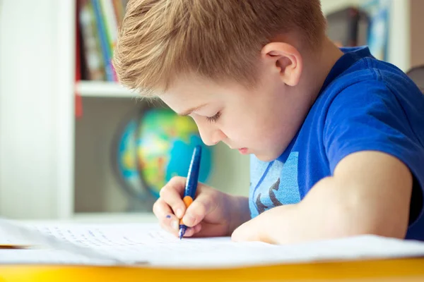 Intelligent boy makes homework in his room — Stock Photo, Image