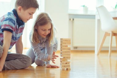 İki mutlu kardeşler ahşap bloklar evde bir oyun oynuyor