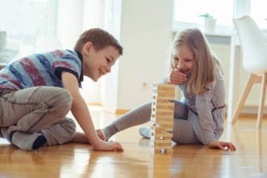 İki mutlu kardeşler ahşap bloklar evde bir oyun oynuyor