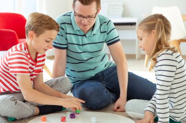 Mutlu genç baba iki neşeli kardeşiyle oynuyor.