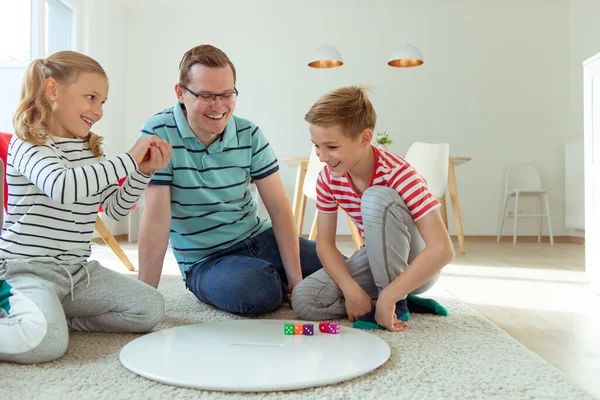 Ευτυχισμένος νεαρός πατέρας παίζει με τα δύο χαρούμενα αδέλφια του παιδιά — Φωτογραφία Αρχείου