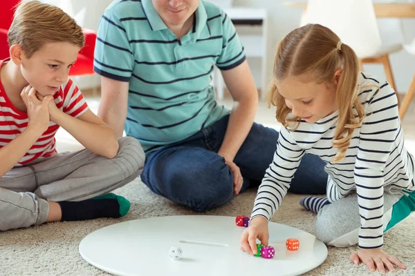 Gelukkig jong vader speelt met zijn twee vrolijke broers en zussen kinderen — Stockfoto