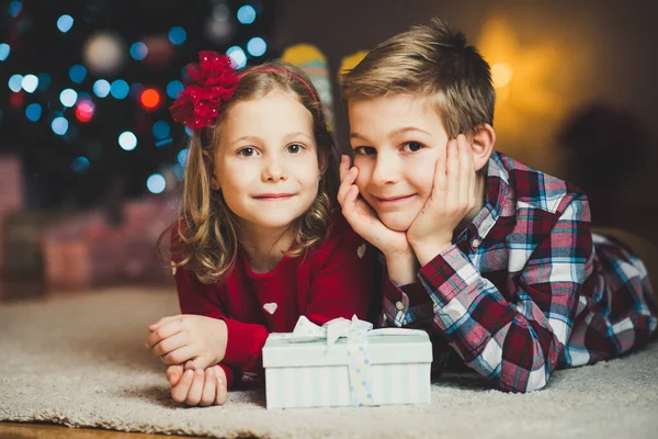 Duas crianças felizes na véspera de ano novo com presentes perto do Ano Novo T — Fotografia de Stock