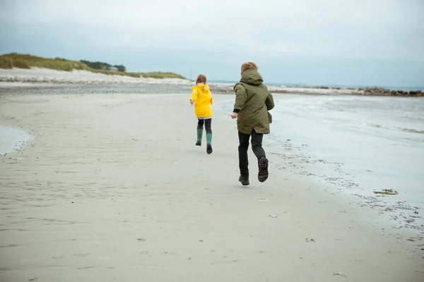 Deux enfants heureux courir et sauter sur l'eau de la mer Baltique dans — Photo