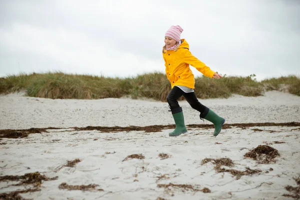 Vidám kislány fut a víz a Balti-tenger gumi bo — Stock Fotó