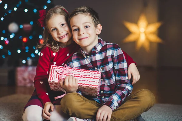 Dos niños felices en la víspera de año nuevo con regalos cerca de Año Nuevo T —  Fotos de Stock