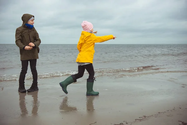 Två glada barn springer och hoppar på vattnet i Östersjön i — Stockfoto
