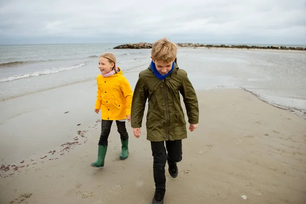Dos niños felices corriendo y saltando sobre el agua del mar Báltico en — Foto de Stock