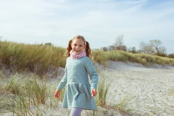 Портрет досить веселої маленької дівчинки в сукні в сонячний день — стокове фото