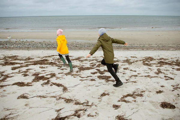 Zwei glückliche Kinder laufen und springen auf dem Wasser der Ostsee in — Stockfoto