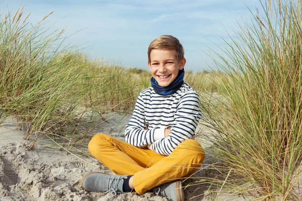英俊少年坐在沙滩白沙滩上的画像 — 图库照片