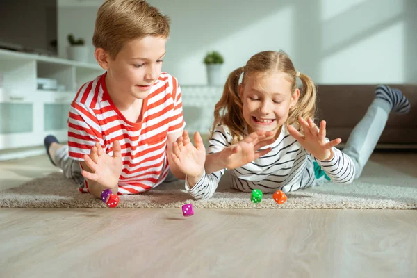 Retrato de dos niños alegres tirados en el suelo y jugando — Foto de Stock