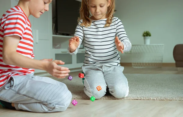 Portret van twee vrolijke kinderen die op de vloer liggen en spelen — Stockfoto