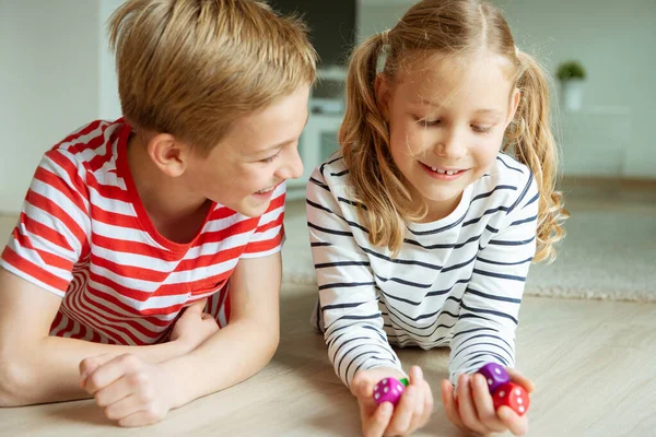 Portrait of two cheerful children laying on the floor and playin — Stock Photo, Image