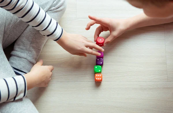 Zwei schlaue Kinder studieren Mathematik und spielen mit Würfeln auf der — Stockfoto