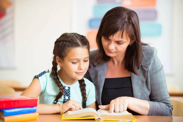 Yong mooie leraar met schoolmeisje school — Stockfoto