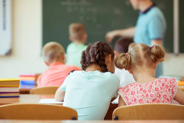 Skolpojke med sin lärare på svarta tavlan på mattelektion i — Stockfoto