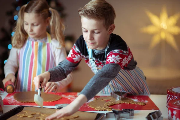 Happy siblings children preparing Christmas cookies at home with — Stock Photo, Image