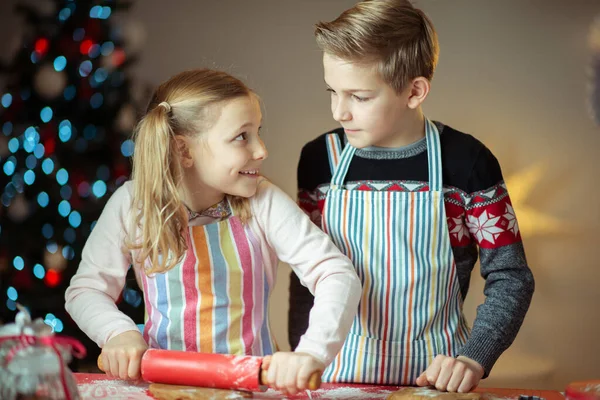 Felices hermanos niños preparando galletas de Navidad en casa con —  Fotos de Stock