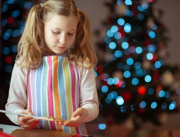 Jolie petite fille décorant biscuits de Noël à la maison avec ch — Photo