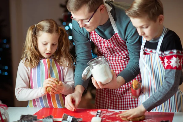 Feliz padre con sus hijos hornea galletas de jengibre para Christma —  Fotos de Stock