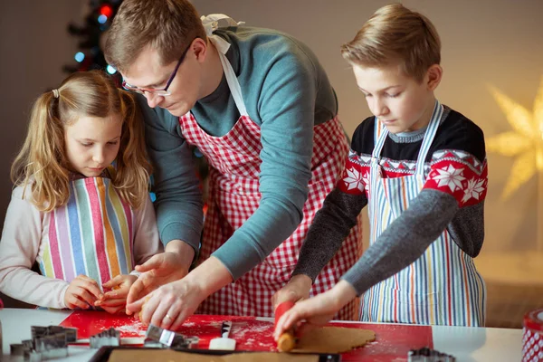 Lycklig far med sina barn bakar ingefära kakor till Christma — Stockfoto