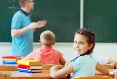 Genç erkek öğretmen matematik dersini karatahtada anlatıyordu.