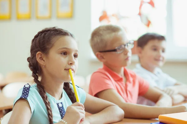 Söta skolbarn studerar och svarar på frågor i klassrummet under — Stockfoto