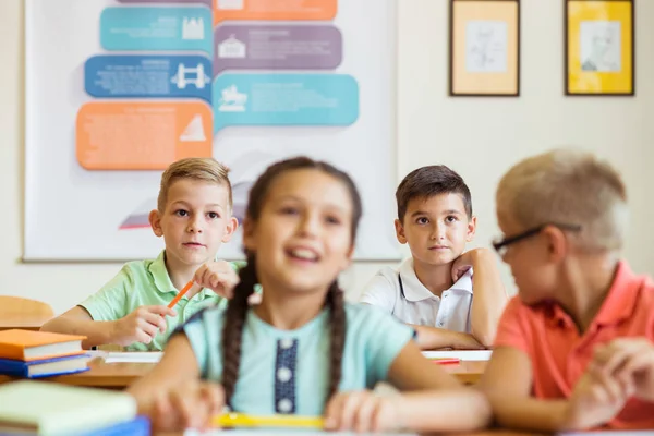 Cute schoolchildren study and answer questions in classroom duri — Stock Photo, Image