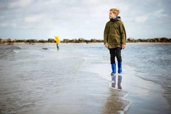 Dwoje szczęśliwych dzieci spacerujących w wodzie na plaży Morza Bałtyckiego i — Zdjęcie stockowe