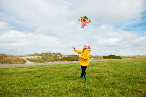 Glada syskon barn som springer och har kul med drake på stranden — Stockfoto