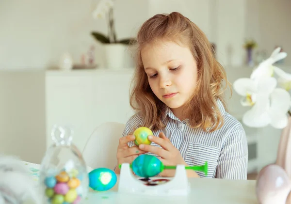 Linda niña rubia pintando huevos de Pascua —  Fotos de Stock