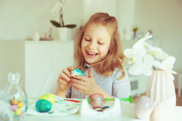 Süßes kleines blondes Mädchen bemalt Ostereier — Stockfoto