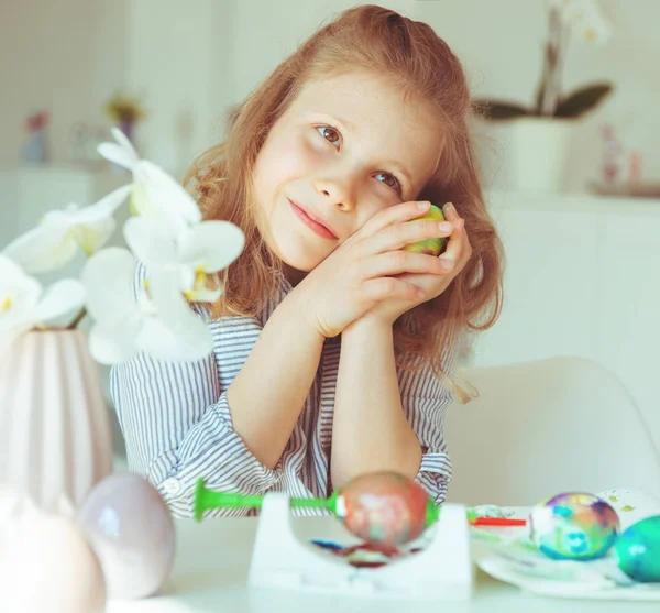 Süßes kleines blondes Mädchen bemalt Ostereier — Stockfoto