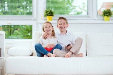 Küçük kardeşim ve kız kardeşi kanepede televizyon izlerken