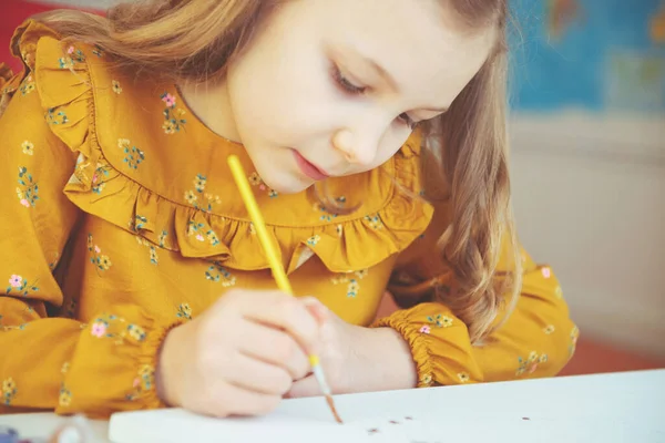 Bella bambina che si accoppia con pastello colorato e pennello — Foto Stock