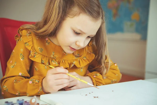 Menina bonita paiting com lápis de cor e pincel — Fotografia de Stock