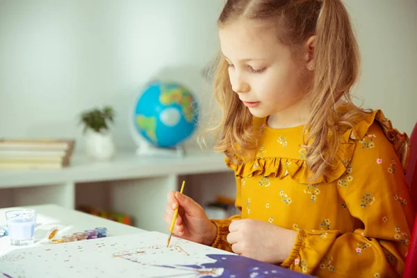 Mooi klein meisje schildert met kleurrijke crayon en paintbrush — Stockfoto