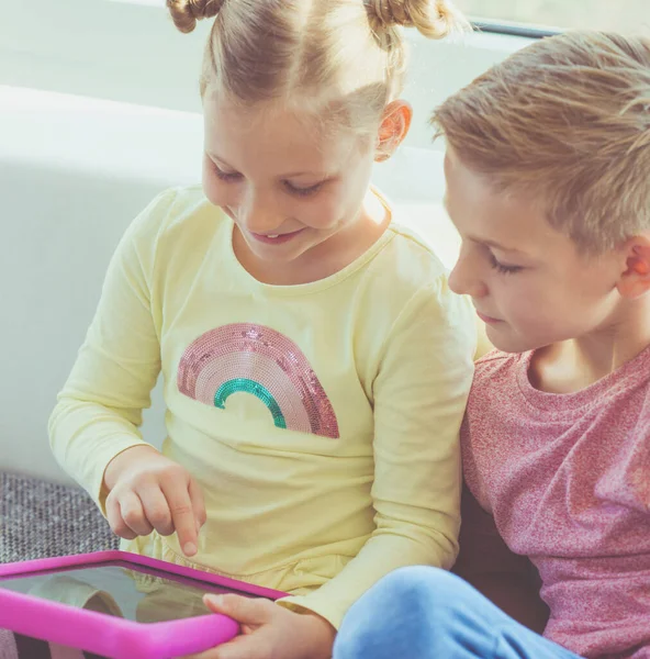 Dos Niños Felices Jugando Con Tableta Casa Sofá —  Fotos de Stock