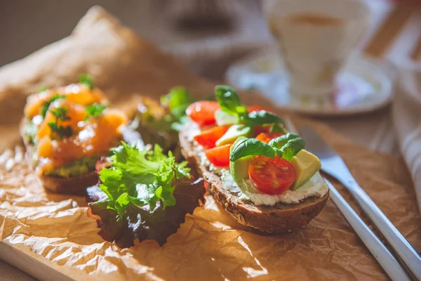 Tostadas Integrales Con Aguacate Tomate Salmón Sobre Tabla Cortar Madera — Foto de Stock