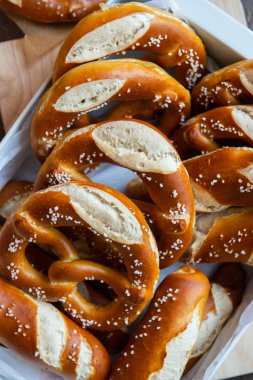 Closeup photo of handmade lye bun and bavarian pretzel in bakery clipart