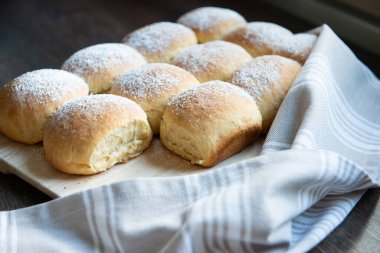 Kabarık ev yapımı Avusturyalı pudralı buchteln. Tahtayla desteklenmiş ve dekore edilmiş.