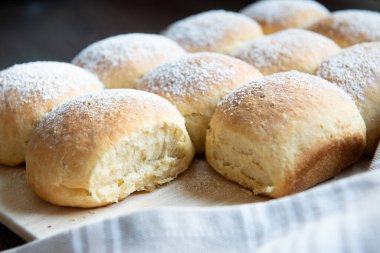 Kabarık ev yapımı Avusturyalı pudralı buchteln. Tahtayla desteklenmiş ve dekore edilmiş.