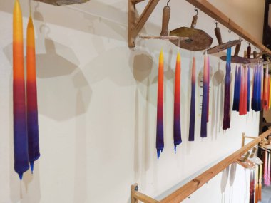 Renkli el yapımı mumlar imalattan sonra balmumu ipe asılmış.