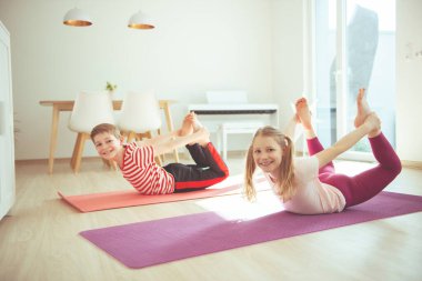 Mutlu kardeşlerim evde yoga yapan çocuklar koronavirüs karantinası altında.